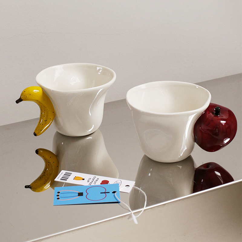 Ceramic mug with 3D apple handle on white background