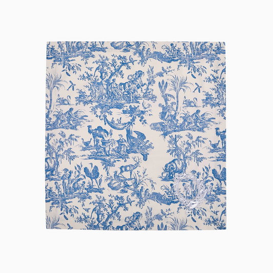 Close-up of blue Toile de Jouy cotton napkins showing the intricate pastoral motif and embroidery.
