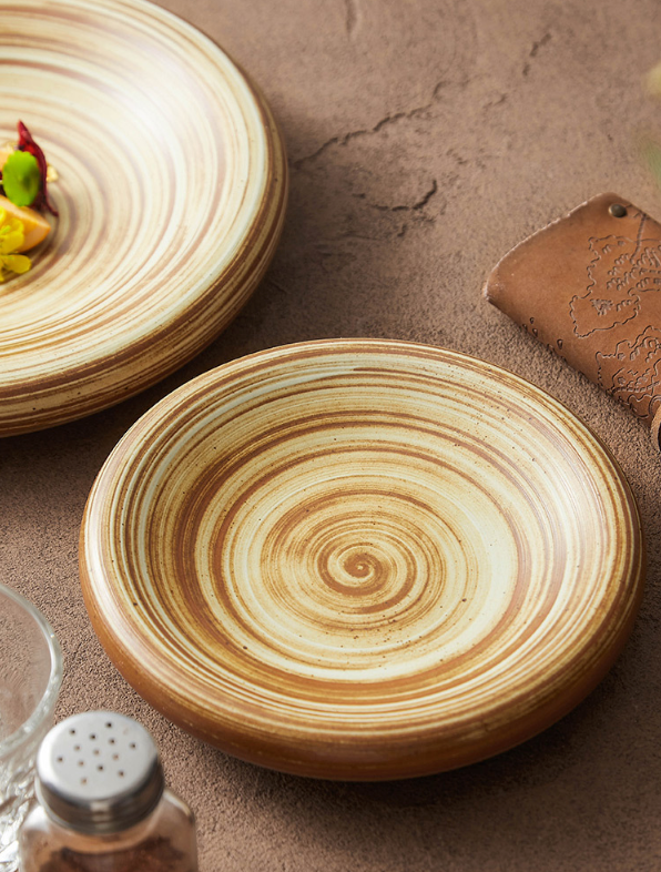 Close-up of ceramic plate with reactive glaze and spiral lines