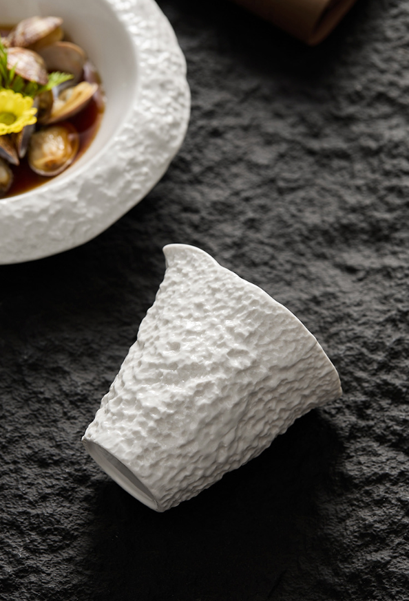 Close-up of modern ceramic sauce cup with stone texture