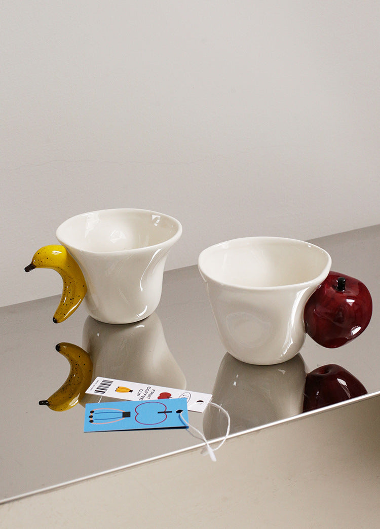 Fruit-themed ceramic mugs displayed side by side