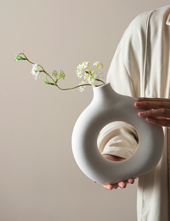 Set of white round ceramic vases on a clean white table