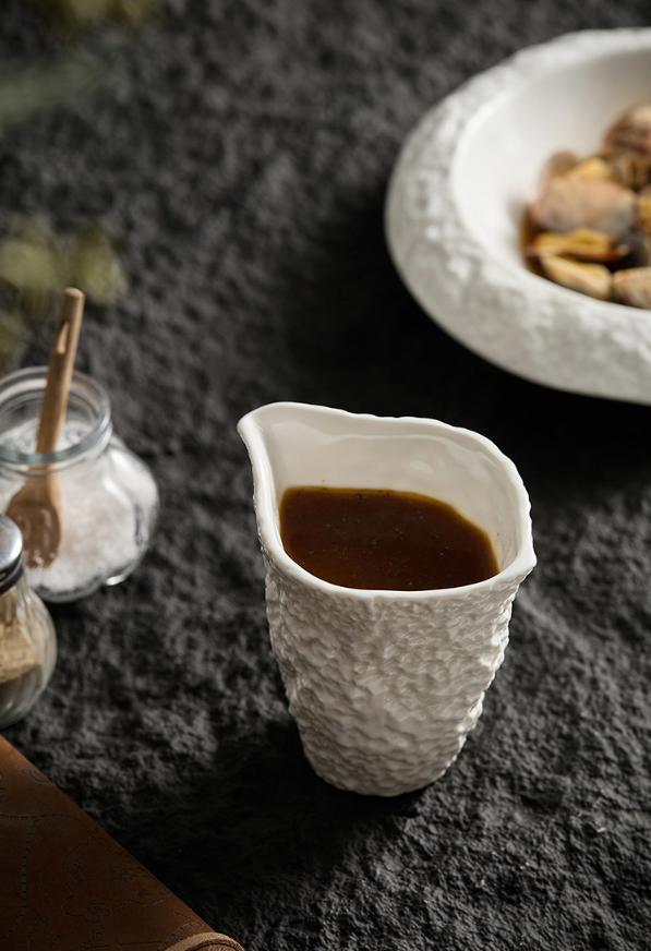 Organic-style ceramic sauce jug with rough surface