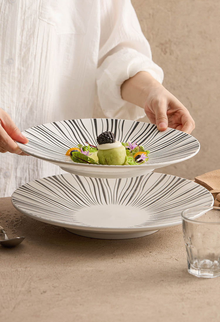 Shallow ceramic plate in contrasting black and white styles