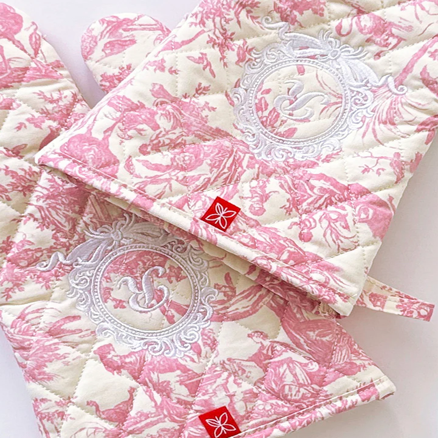 Sophisticated pink oven mitts designed for a refined and artistic culinary space.