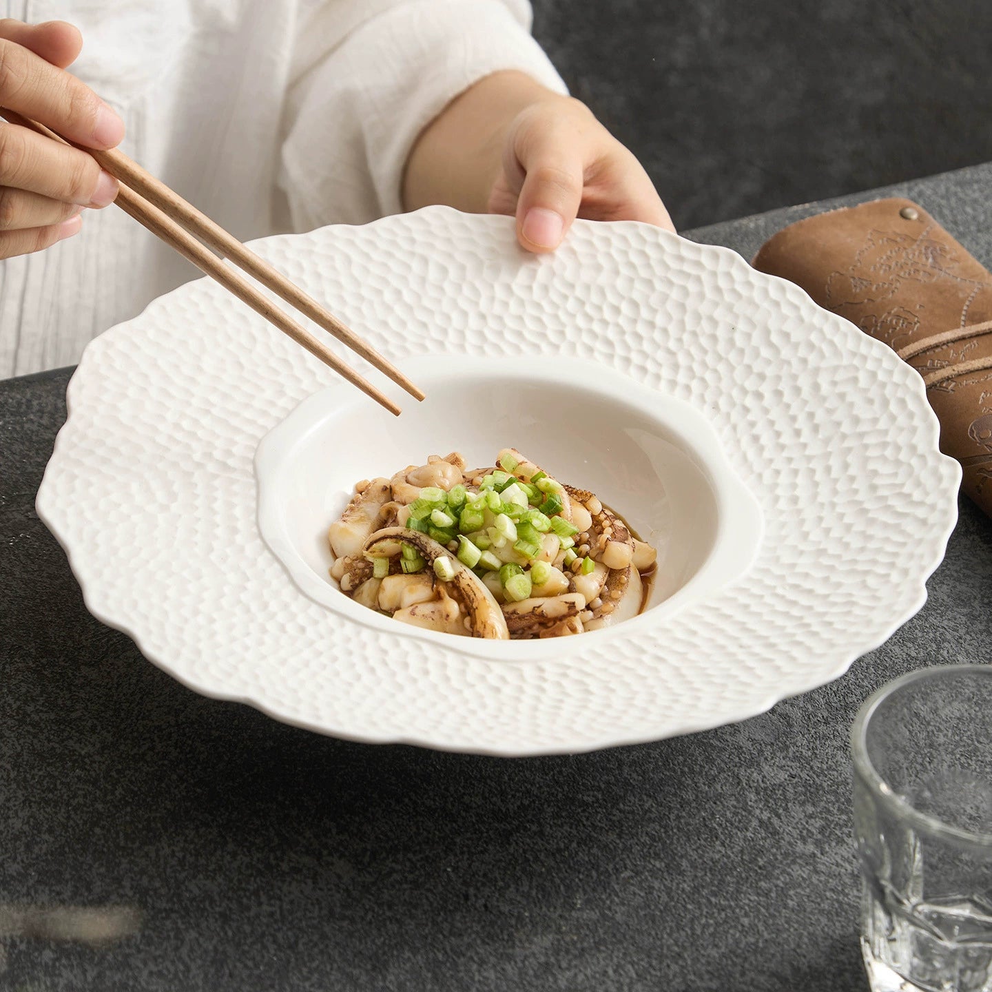 White ceramic plate with petal-shaped edge and hammered texture