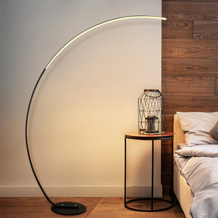 sleek minimalist curved floor lamp glowing in a modern living room