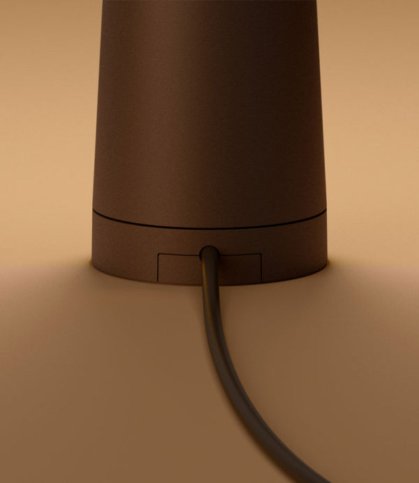 Brown cylindrical object with a power cord on a beige background