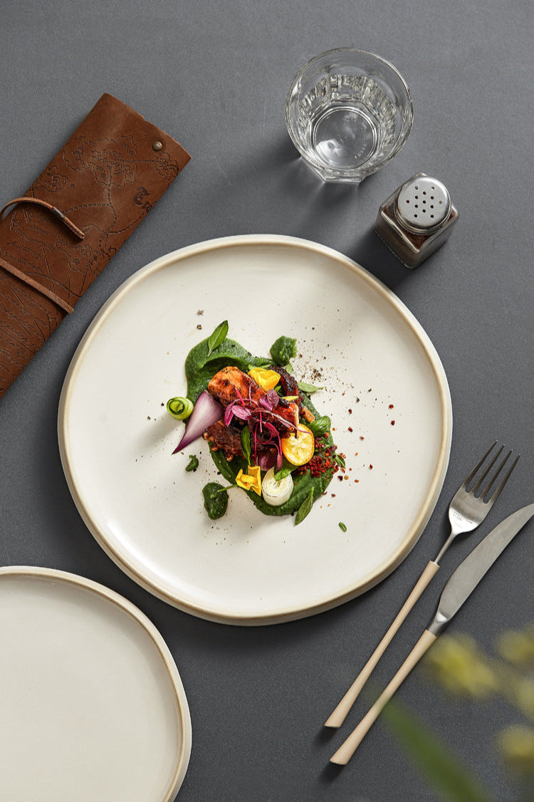 Plated dish of salad with a glass of water and salt shaker on a dark surface