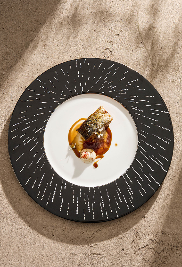 A kinetic white-dotted pattern on a deep black border, inspired by the night sky.