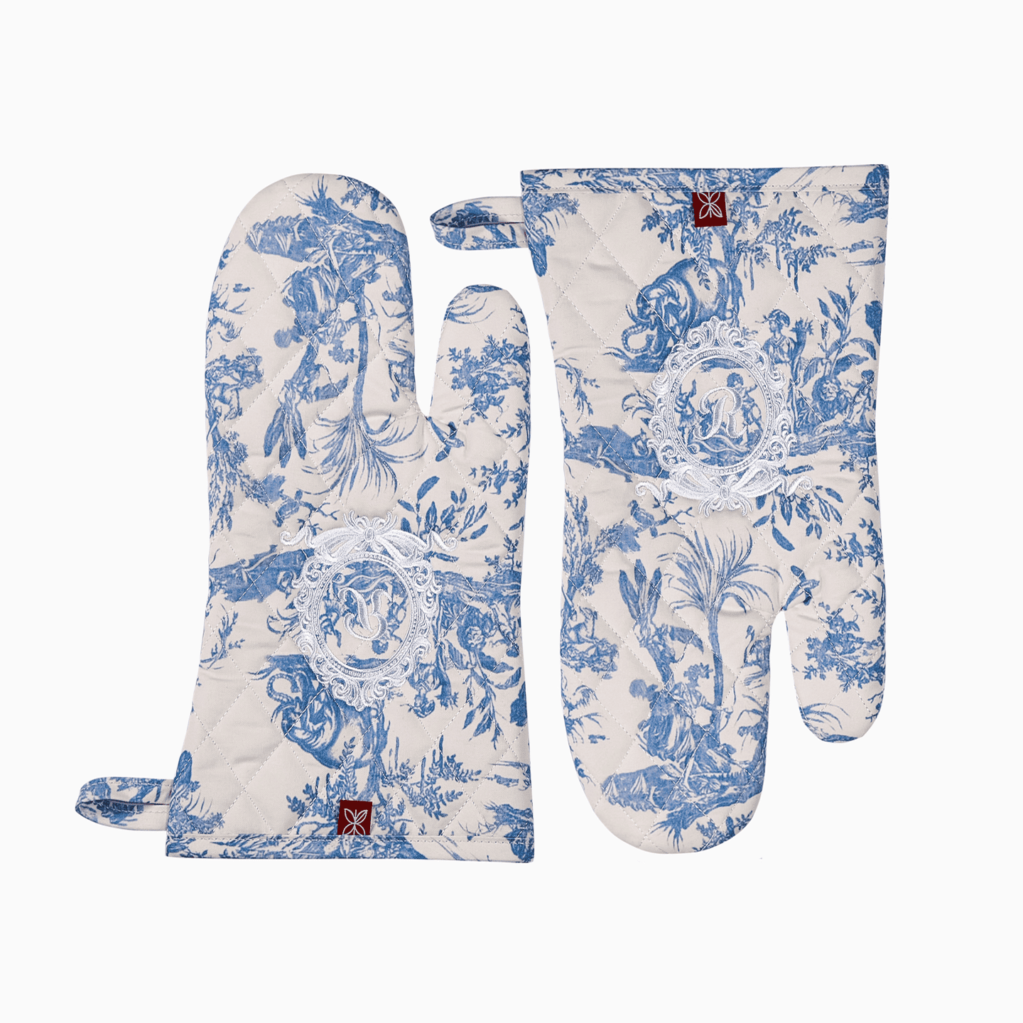 A pair of pink and blue French Toile de Jouy oven mitts displayed together showing royal embroidery.