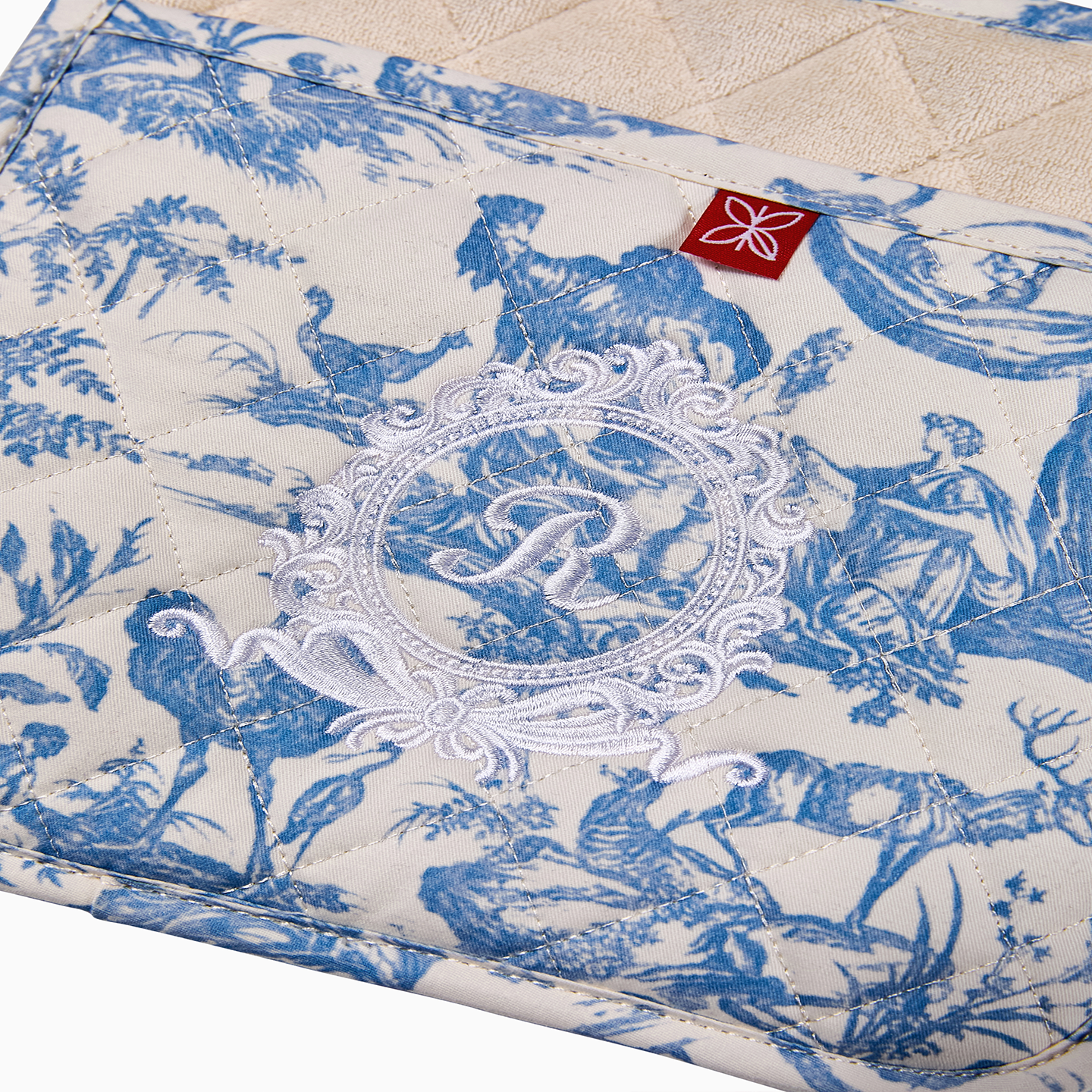 A set of two blue Toile de Jouy pot holders showing the consistent pattern and high-quality embroidery.