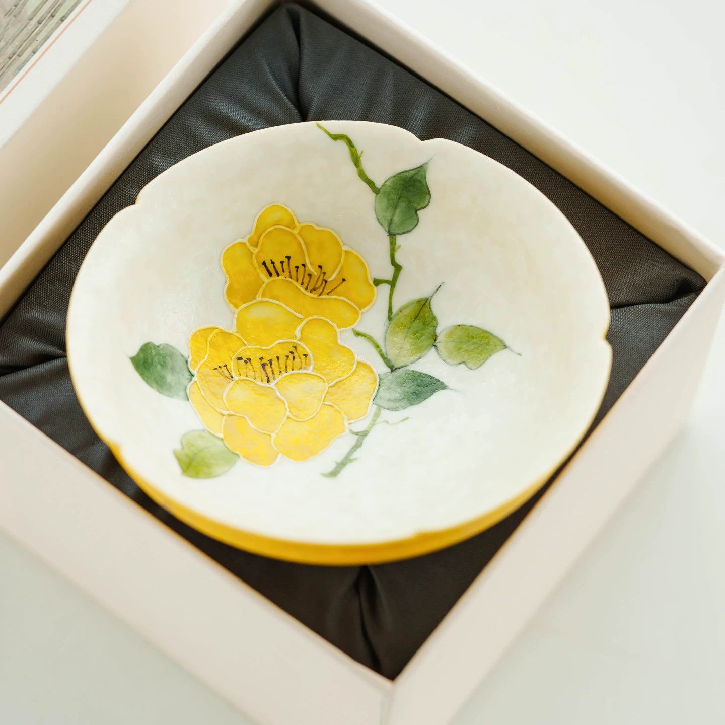 Aerial view of a 50ml porcelain cup featuring a hand-painted yellow camellia.