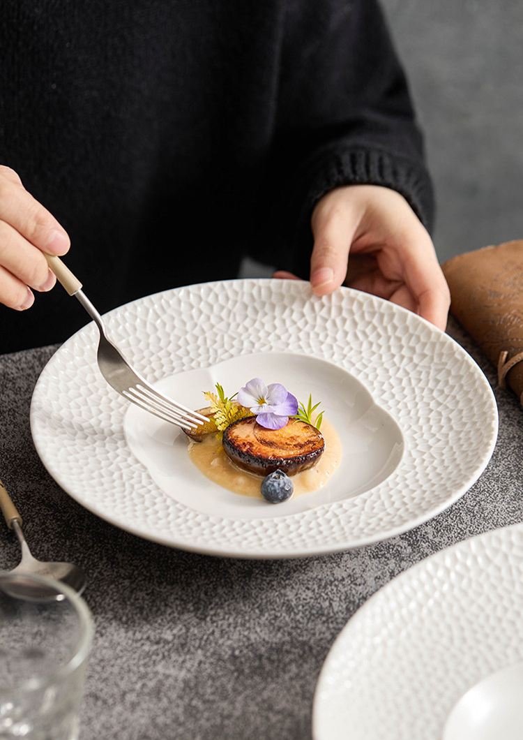 Aerial view of the petal-shaped basin on a matte white professional grade dish.