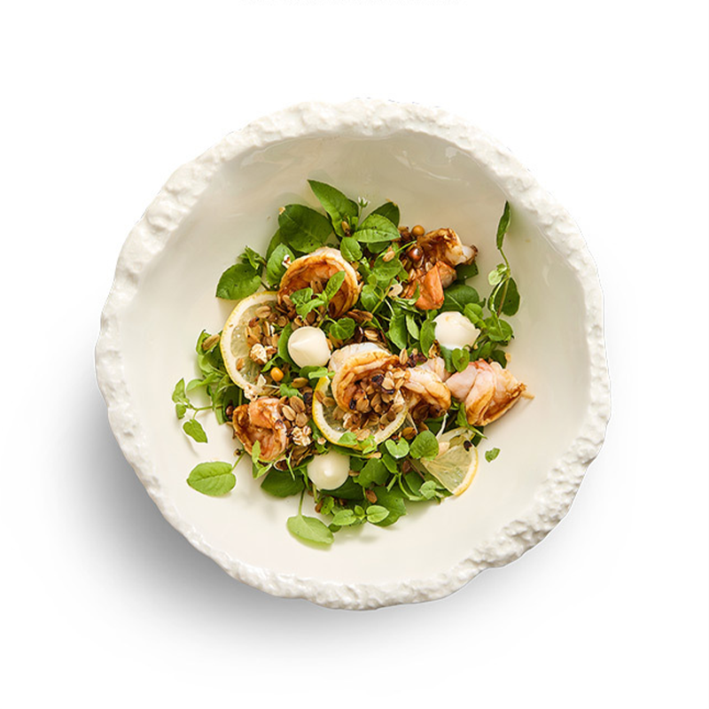 Artisan porcelain salad bowl with tactile rim detail.