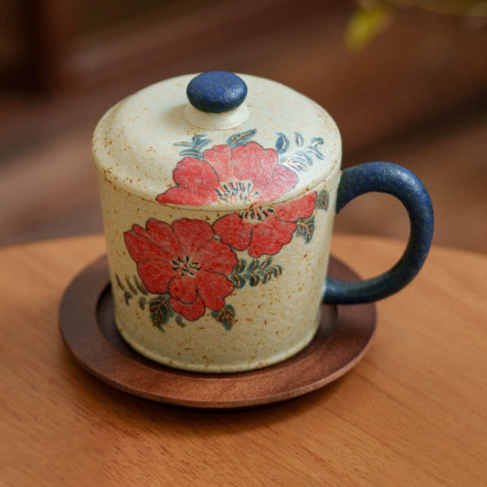 Artisanal ceramic coffee cup with red flower design
