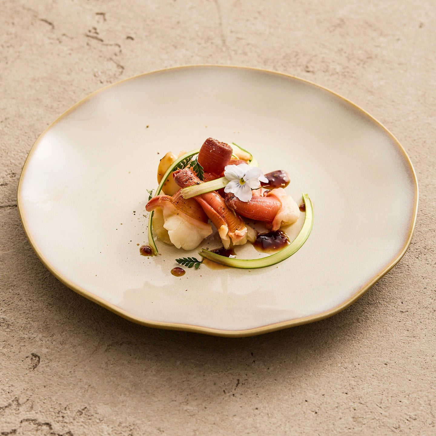 Artisanal kiln-glazed shallow plate featuring a warm tan-brown gradient and a unique wavy-edge rim.