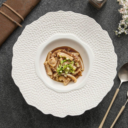 Artistic ceramic dish with deep center and scalloped rim

