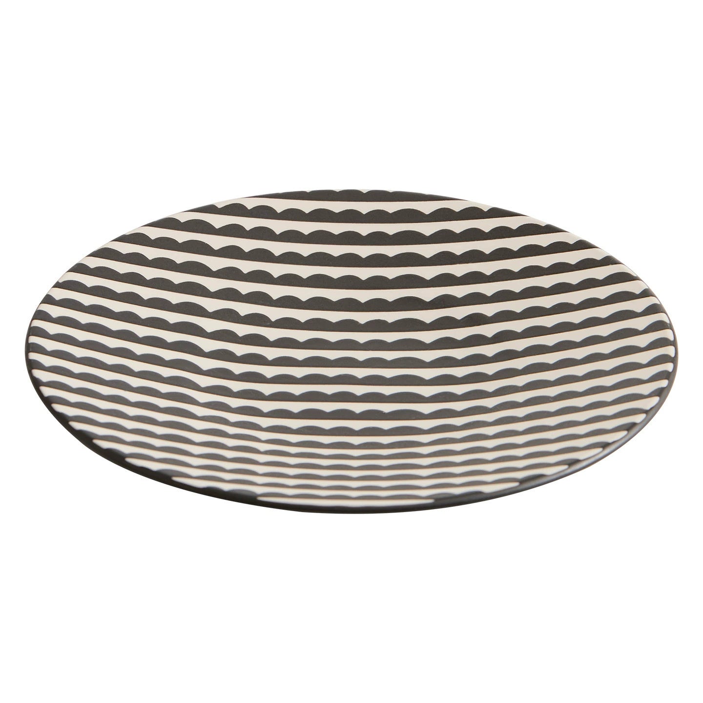 Round ceramic plate with wavy black pattern on a white background