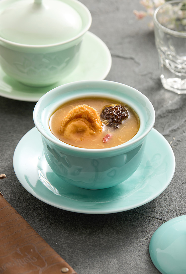 Celadon porcelain stewing bowl with lid and saucer on tabletop