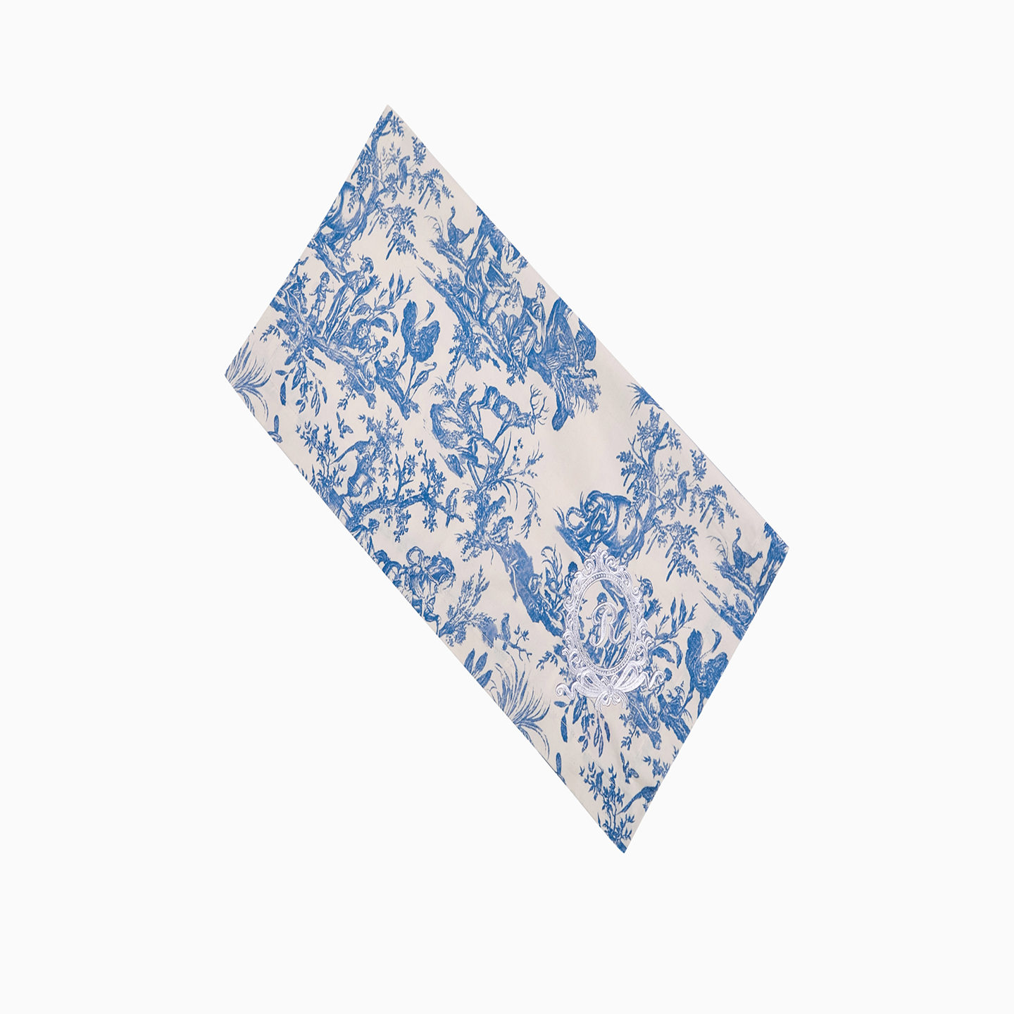 Close-up of blue Toile de Jouy cotton napkins showing the intricate pastoral motif and embroidery.