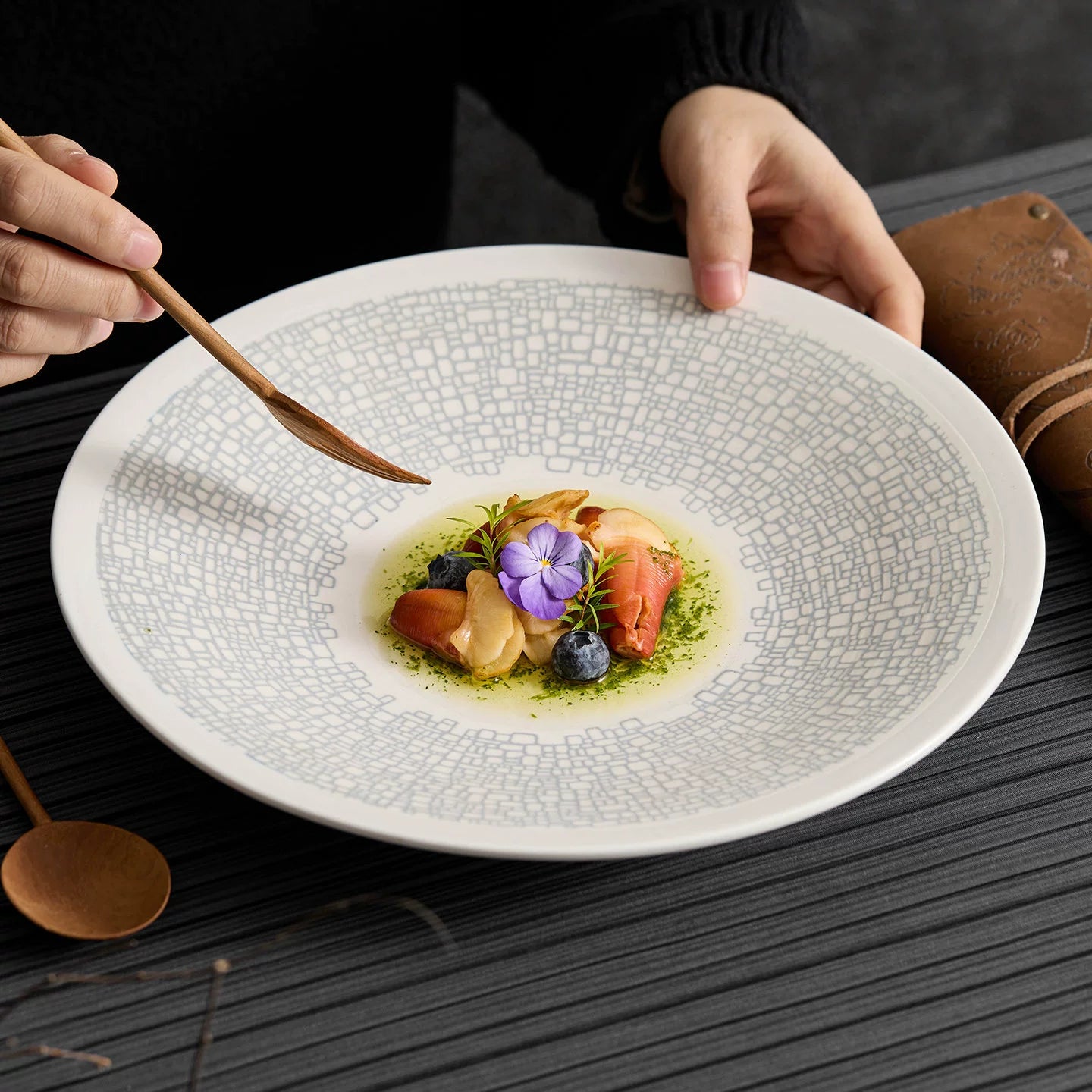 Close-up of intricate geometric mosaic print on a luxury matte ceramic plate.