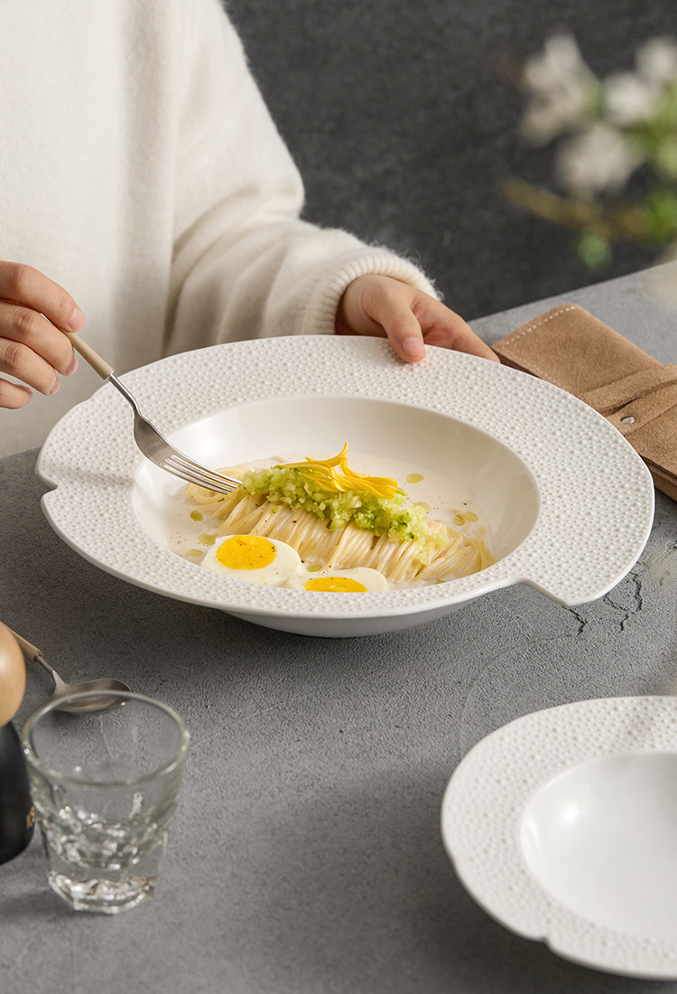 Close-up of sesame point micro-texture on a high-fired white ceramic dish.