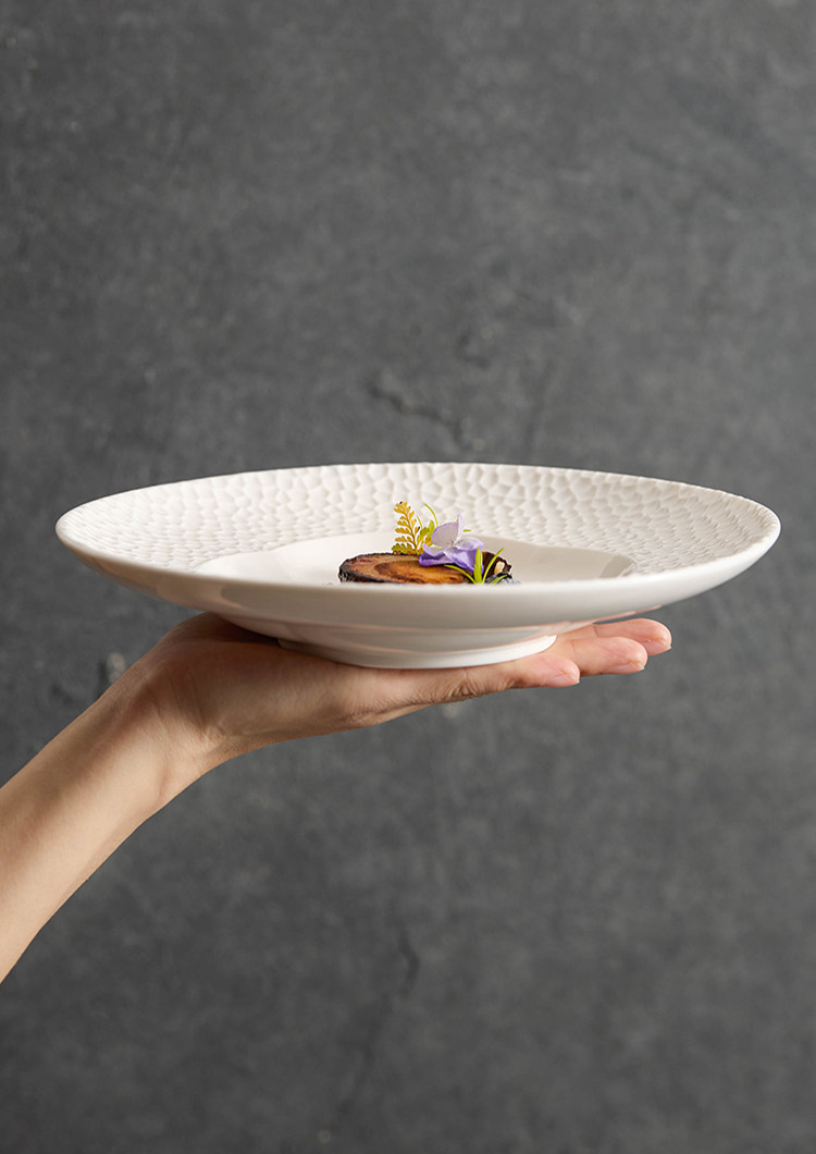 Contemporary matte white tableware with an architectural lattice border.