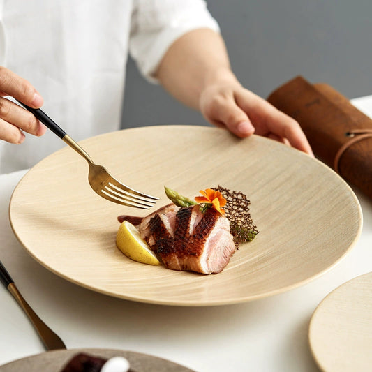 Wooden plate with a piece of meat and garnishes, held by a person.