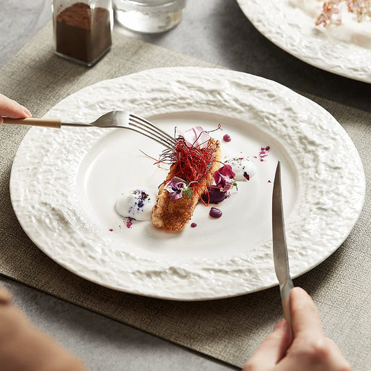 Creative white ceramic dinner plate with sculpted edge

