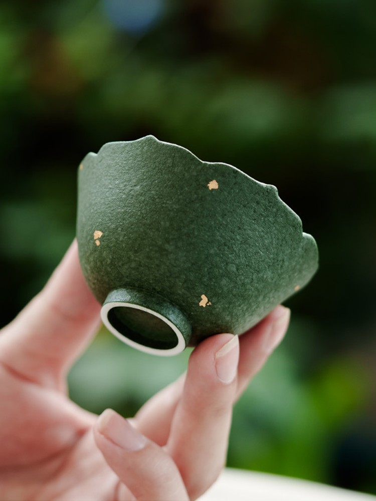 Deep green ceramic teacup with golden speckles