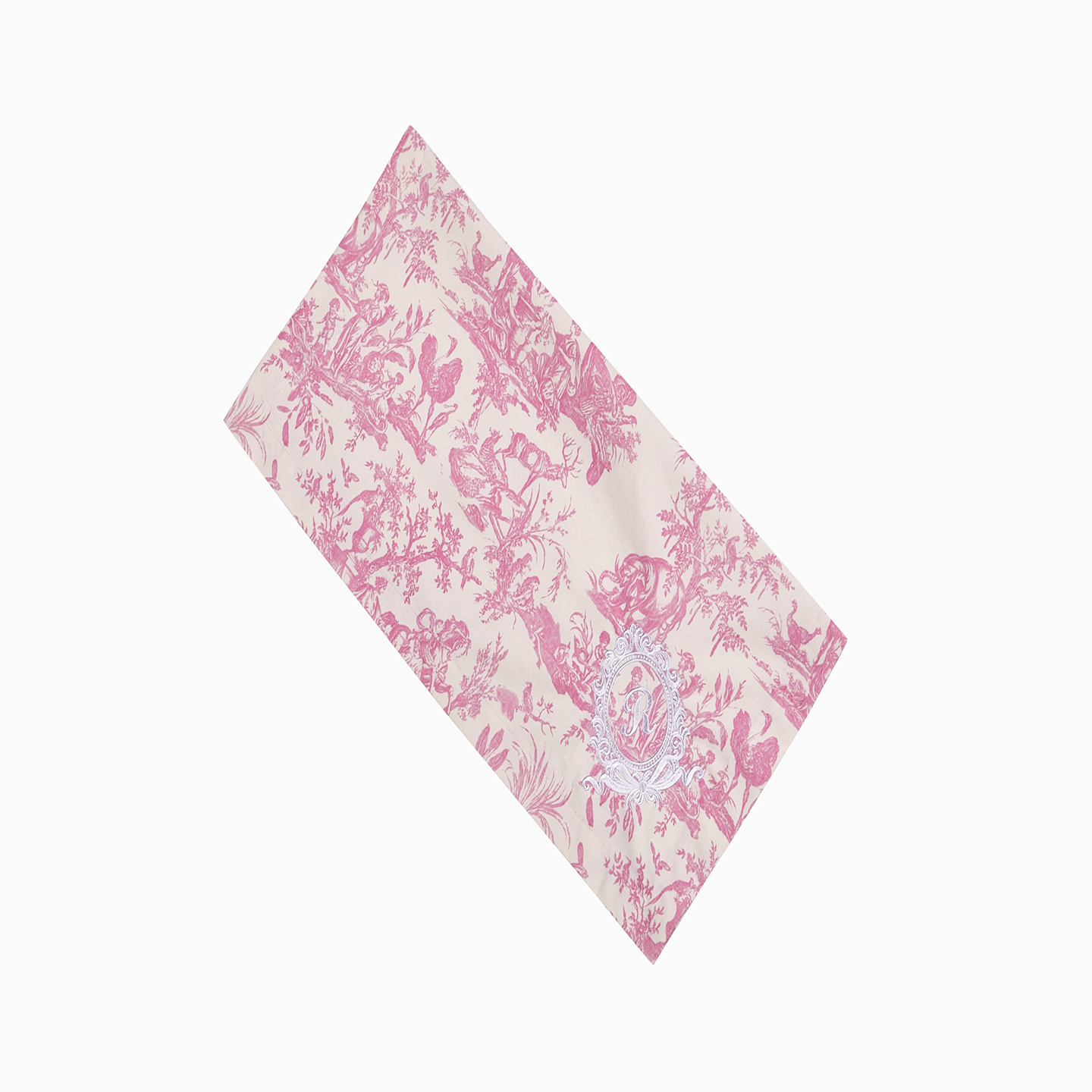 Detailed view of the white "R" royal emblem embroidered on a pink 100% cotton napkin.