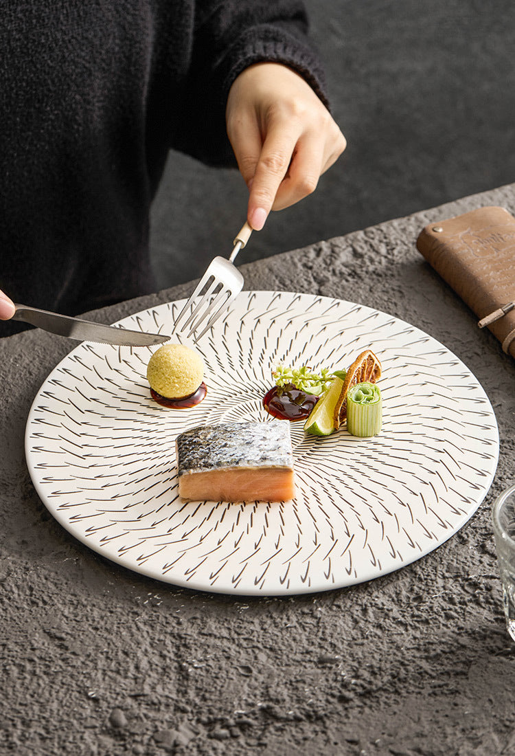 Dessert on a decorative plate with a person about to eat it.