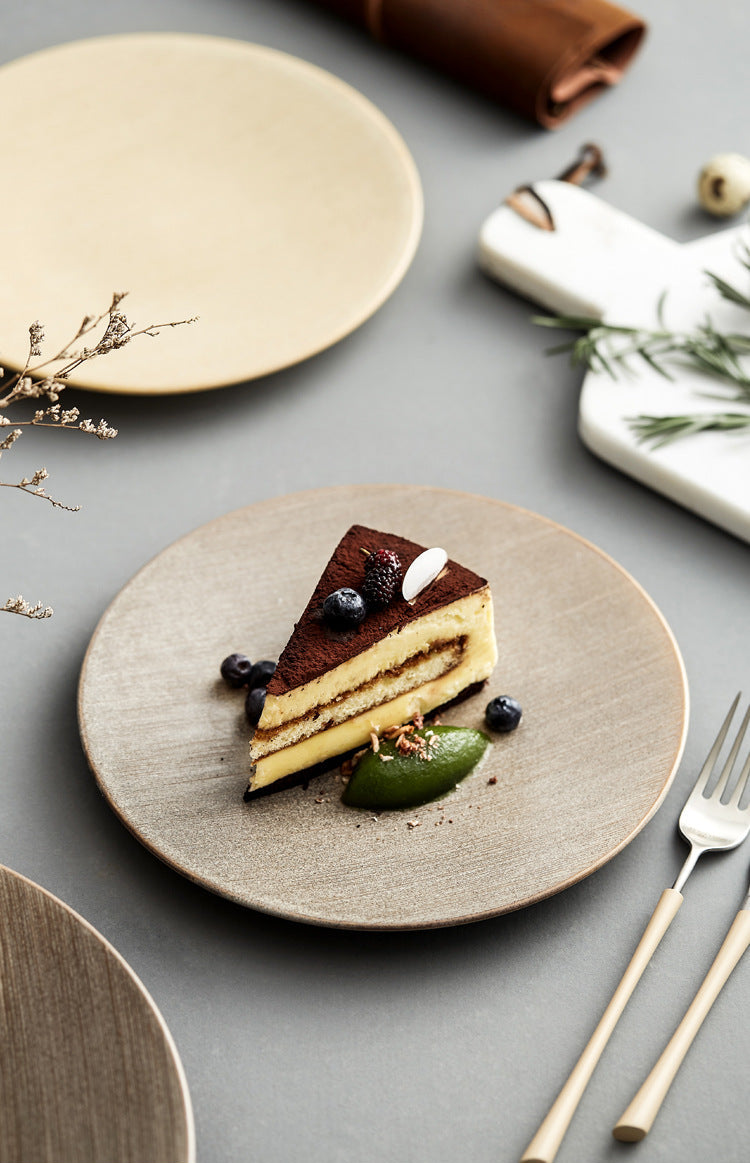 Slice of layered cake on a textured plate with a fork and decorative elements.