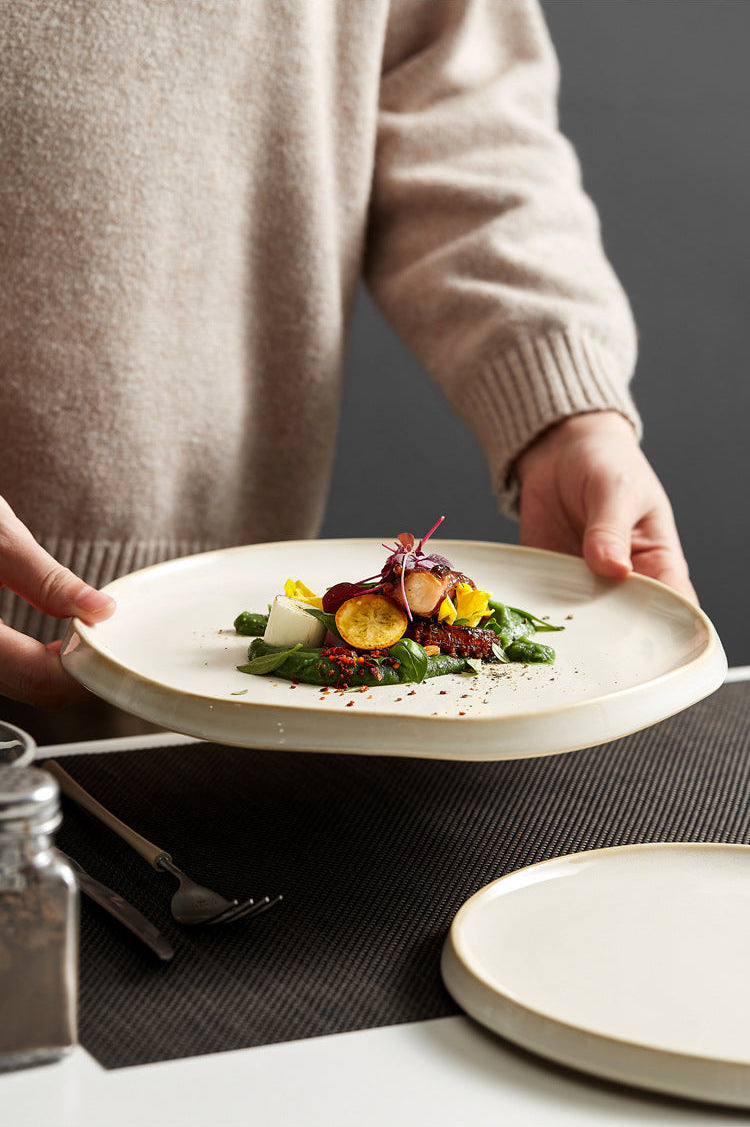 Person holding a plate of salad with a neutral background