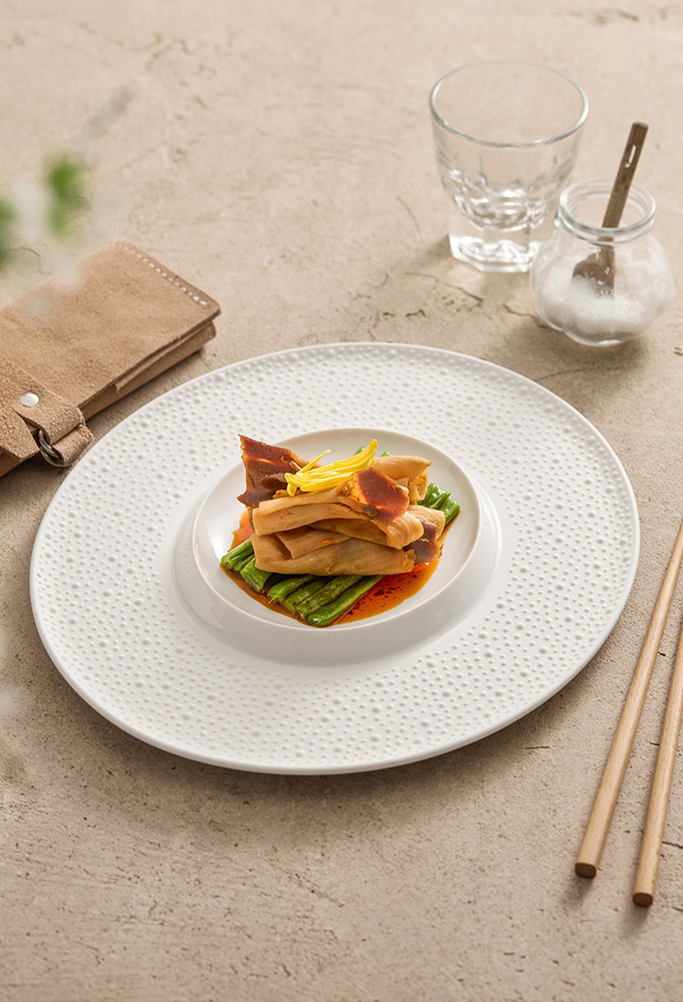 Elegant porcelain plate designed as a quiet frame for modern culinary presentation