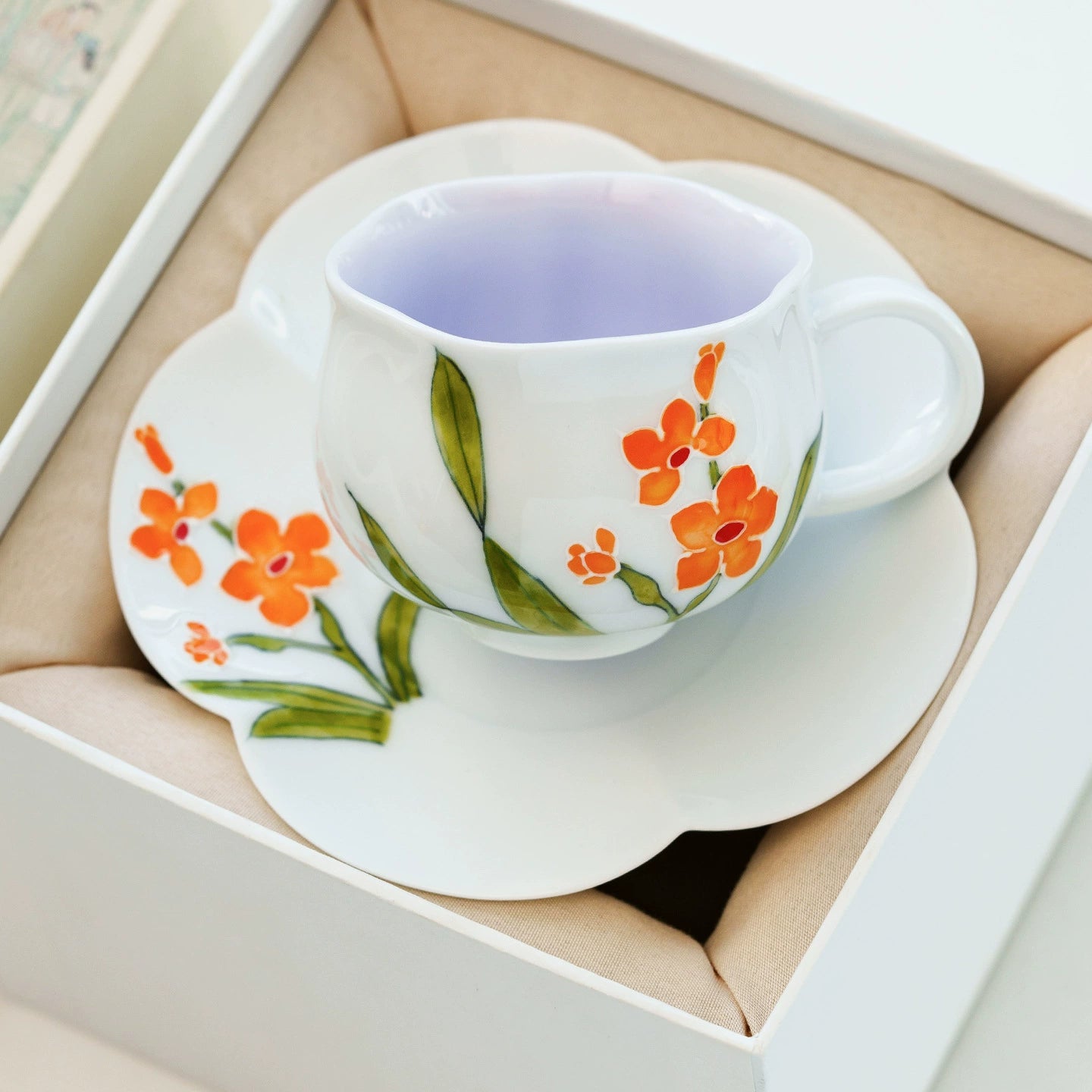 Fine china teacup featuring hand-painted orange petals