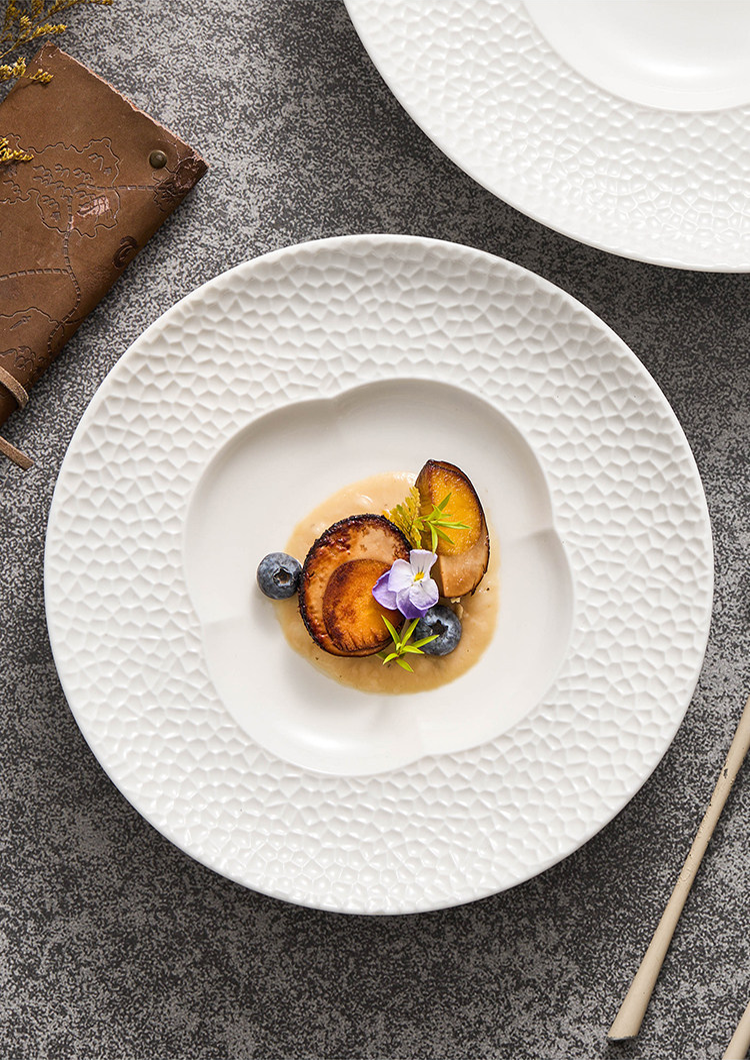 Fine dining presentation using a deep-well blossom plate for centered culinary art.