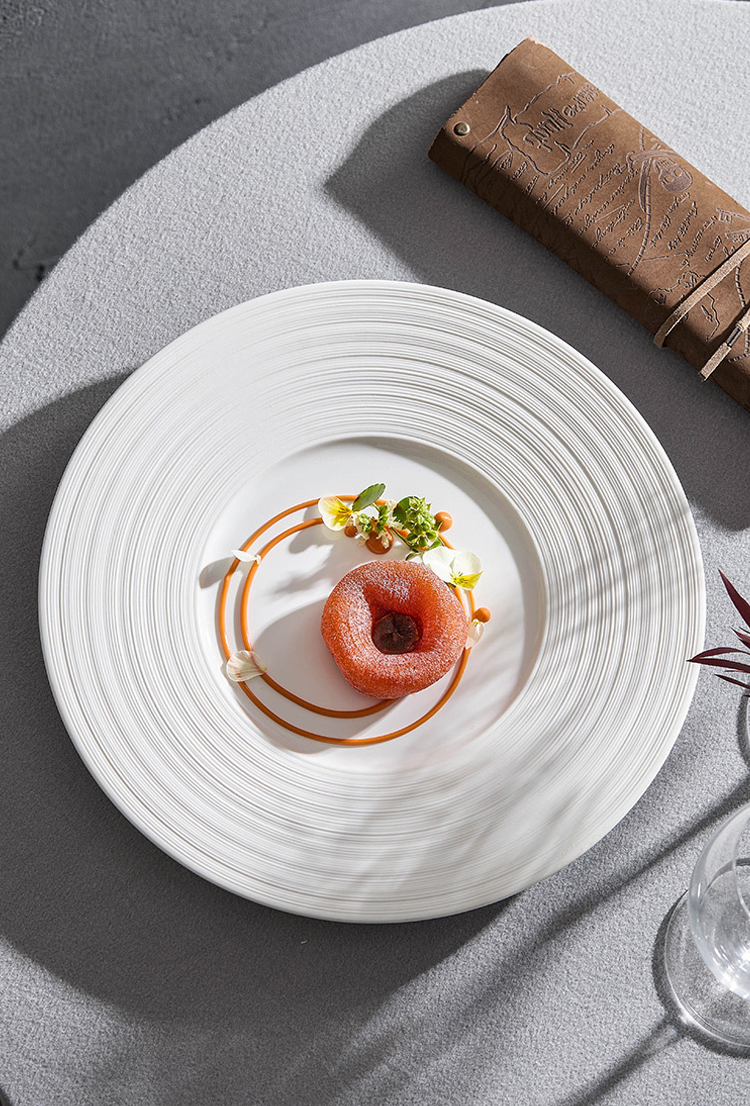 Delicate dish on a white plate with a brown napkin in the background
