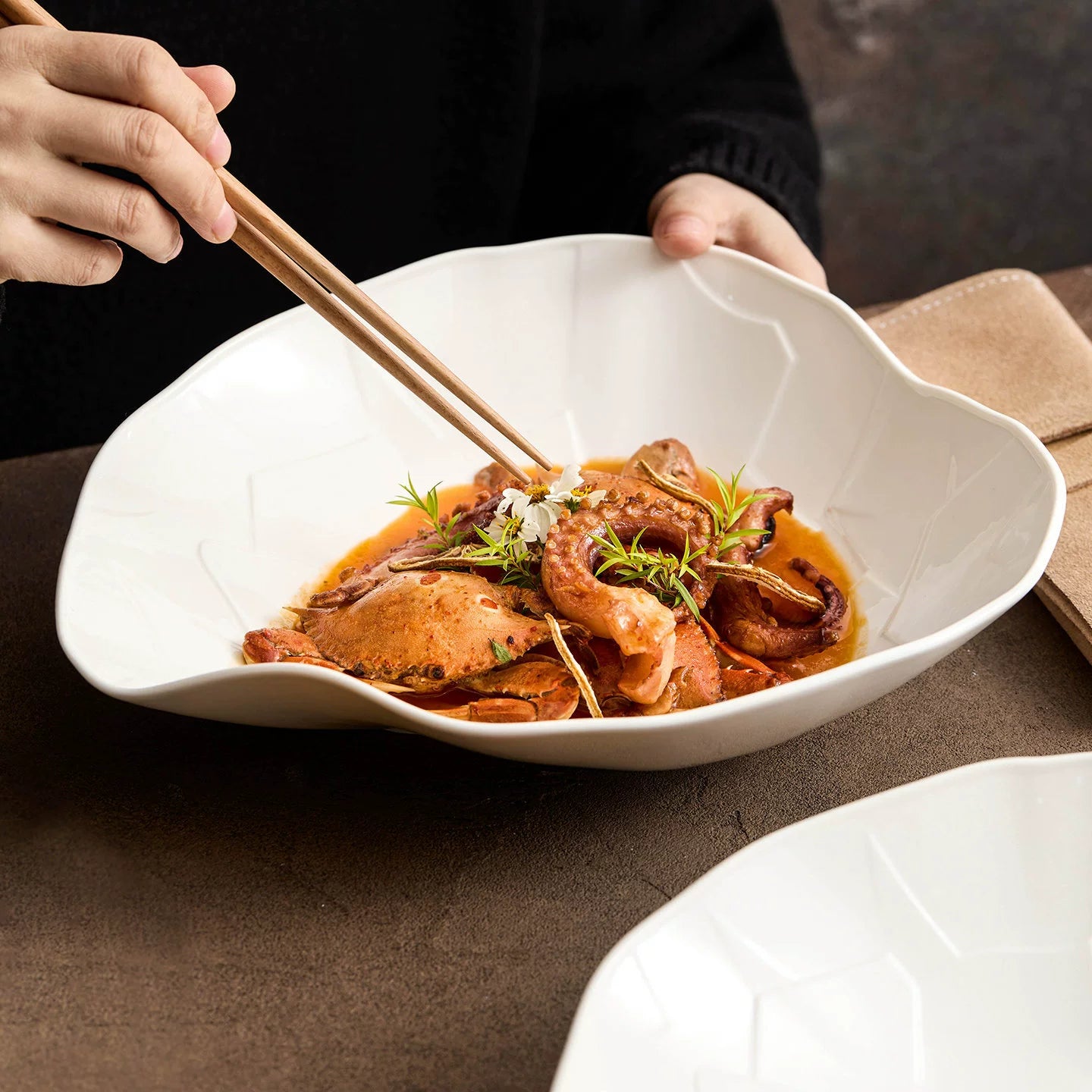 Gourmet seafood plating featuring crab and octopus in a white Pebble Series bowl.