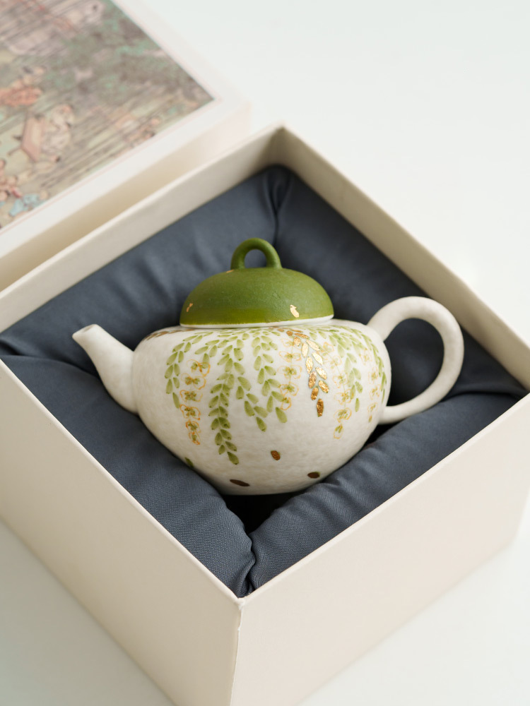 Green ceramic teapot with botanical design