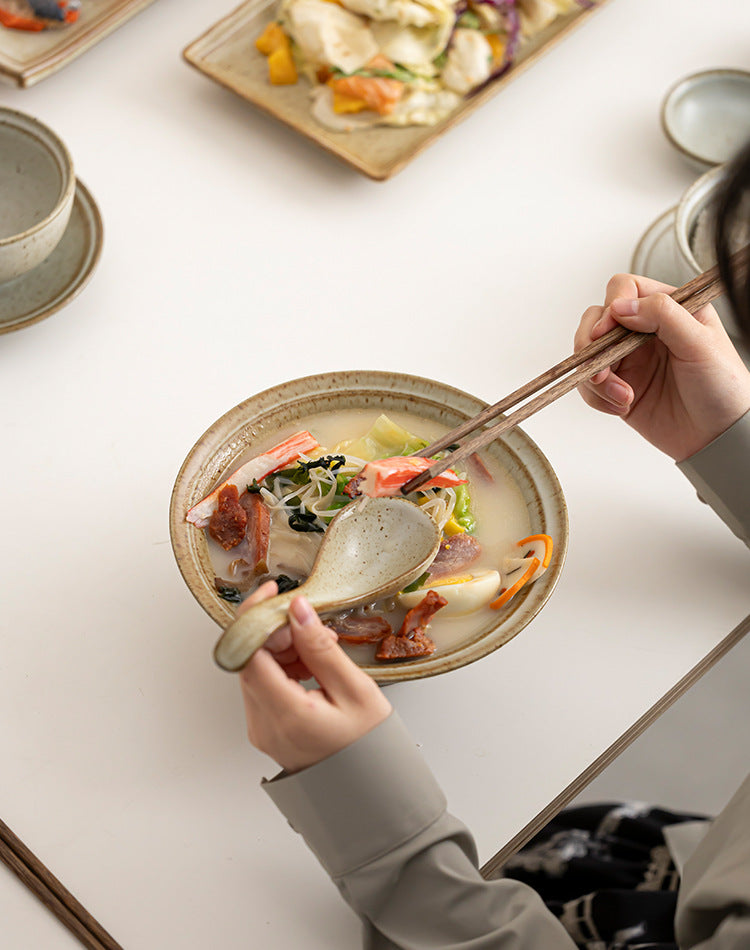 Hand-glazed ceramic plates and bowls in soft beige and earthy textures

