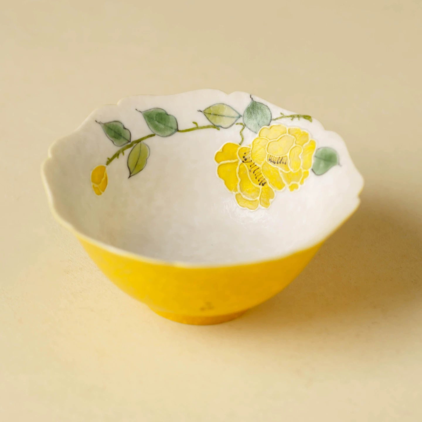 Hand-painted yellow blossom porcelain tea cup with a wavy, fluted "Lingban" petal rim.