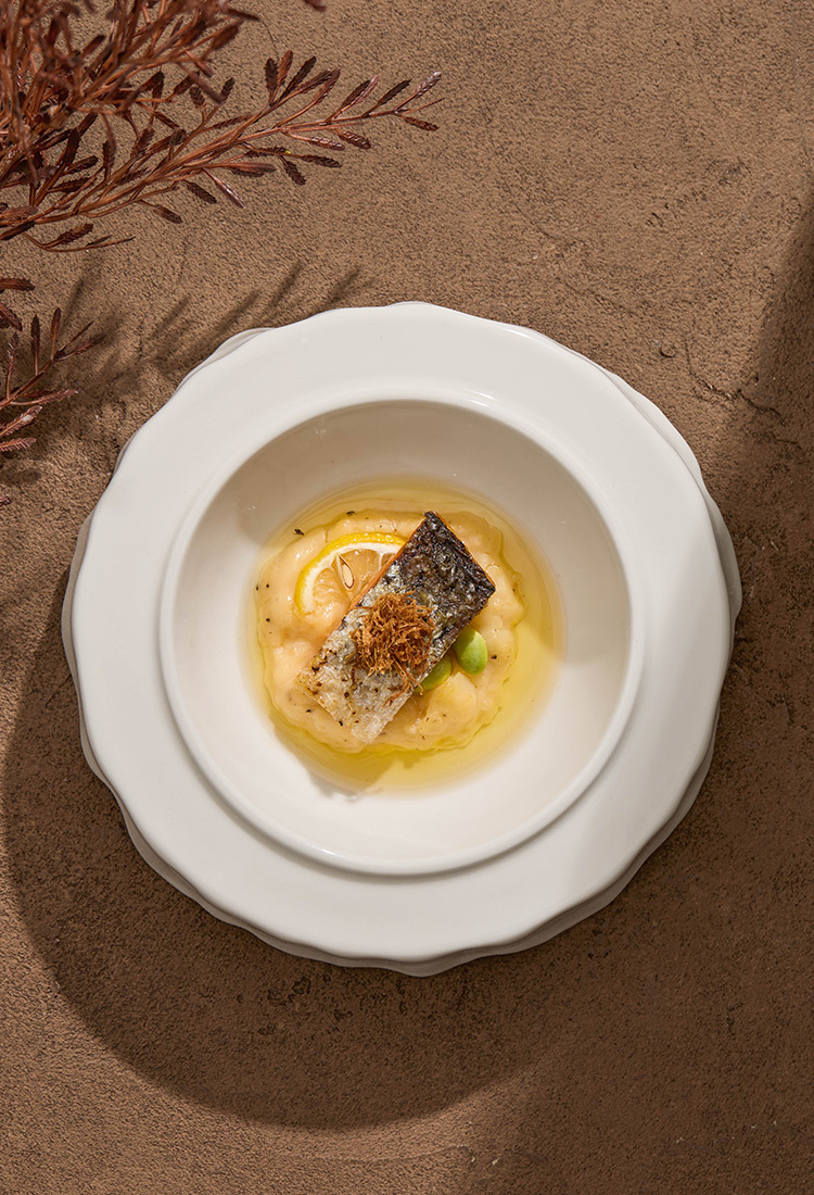 Handcrafted asymmetric plate with matte glaze and fluid form.