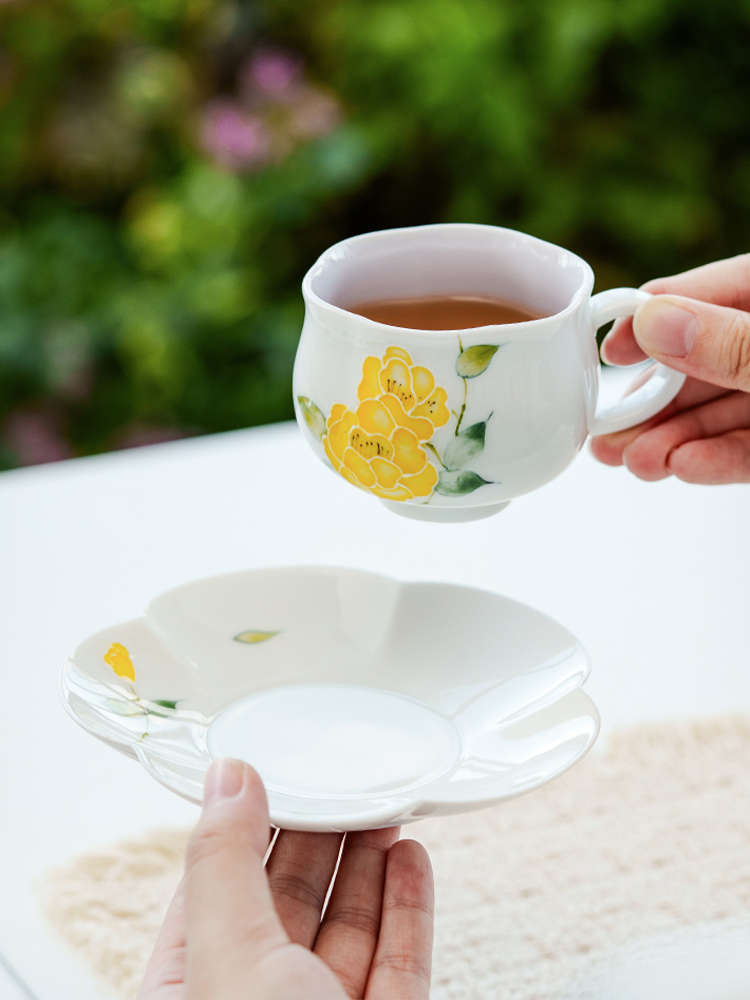 Handcrafted ceramic tea cup with petal-shaped saucer