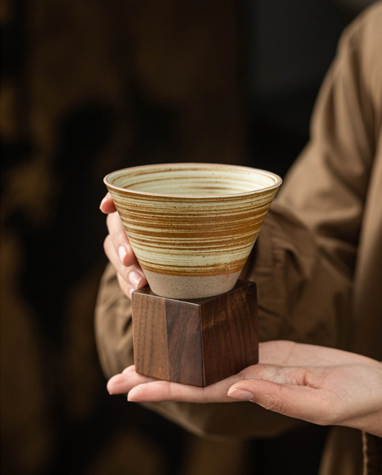 Hand holding artisan ceramic coffee cup
