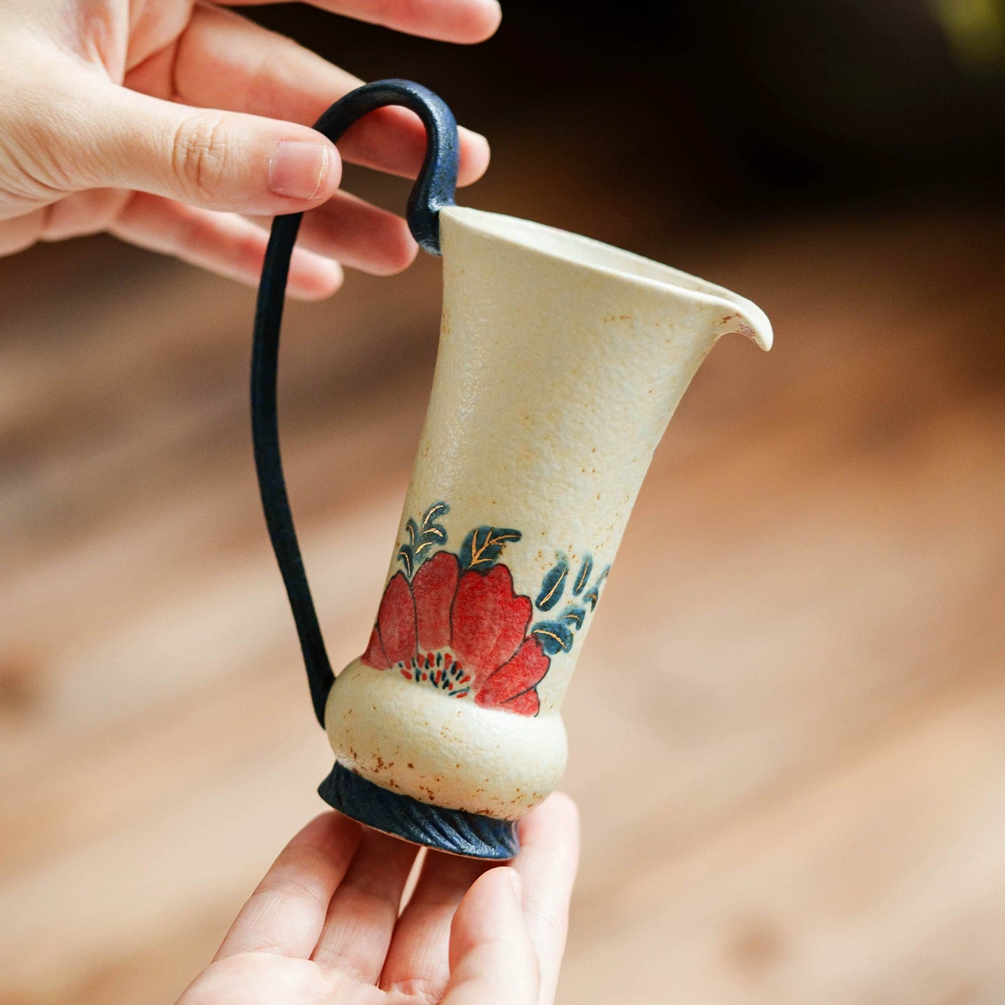 Handmade ceramic pouring cup with red flower design