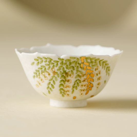 Handmade ceramic teacup with small green leaf motif