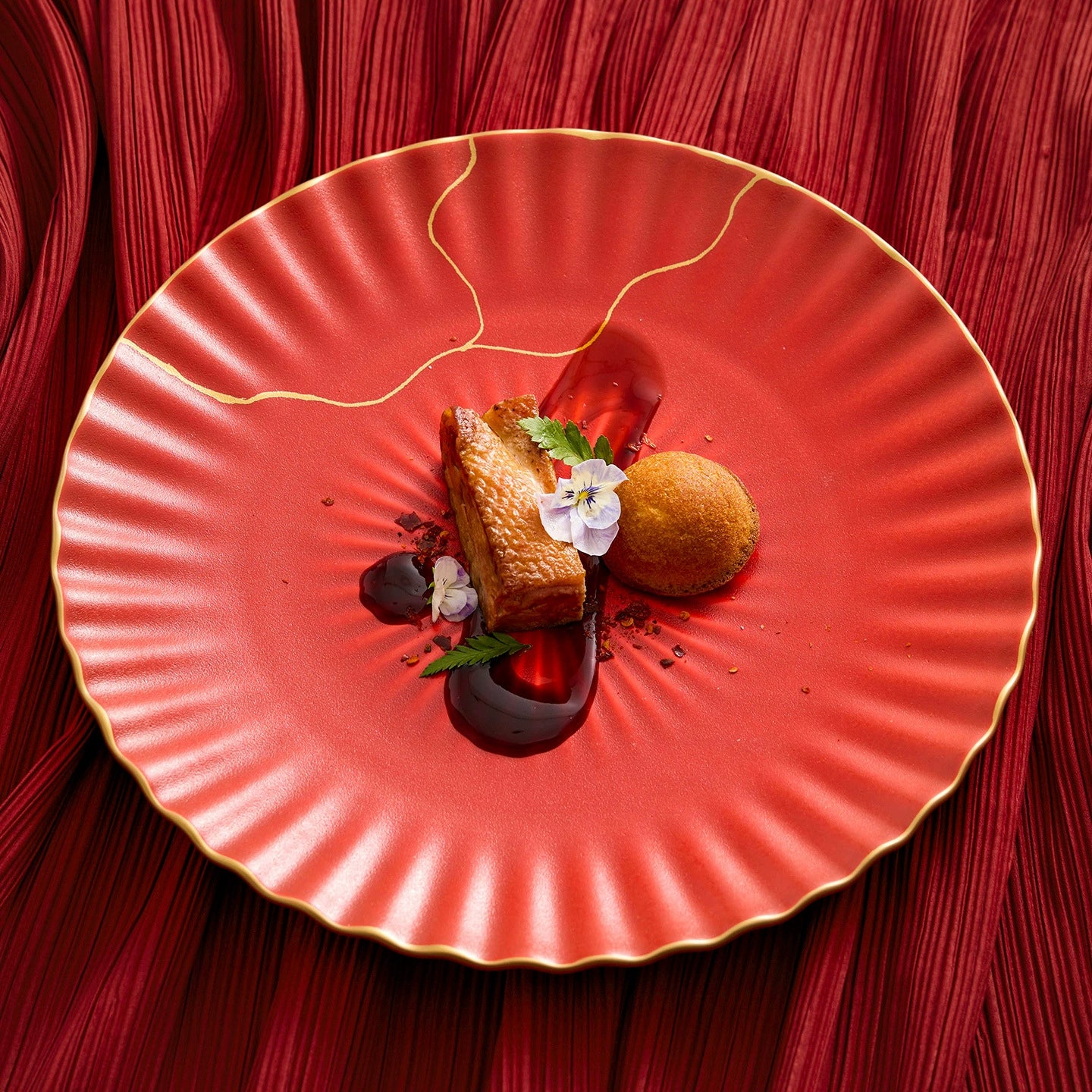 Delicate dessert presentation on a red plate with a red textured background