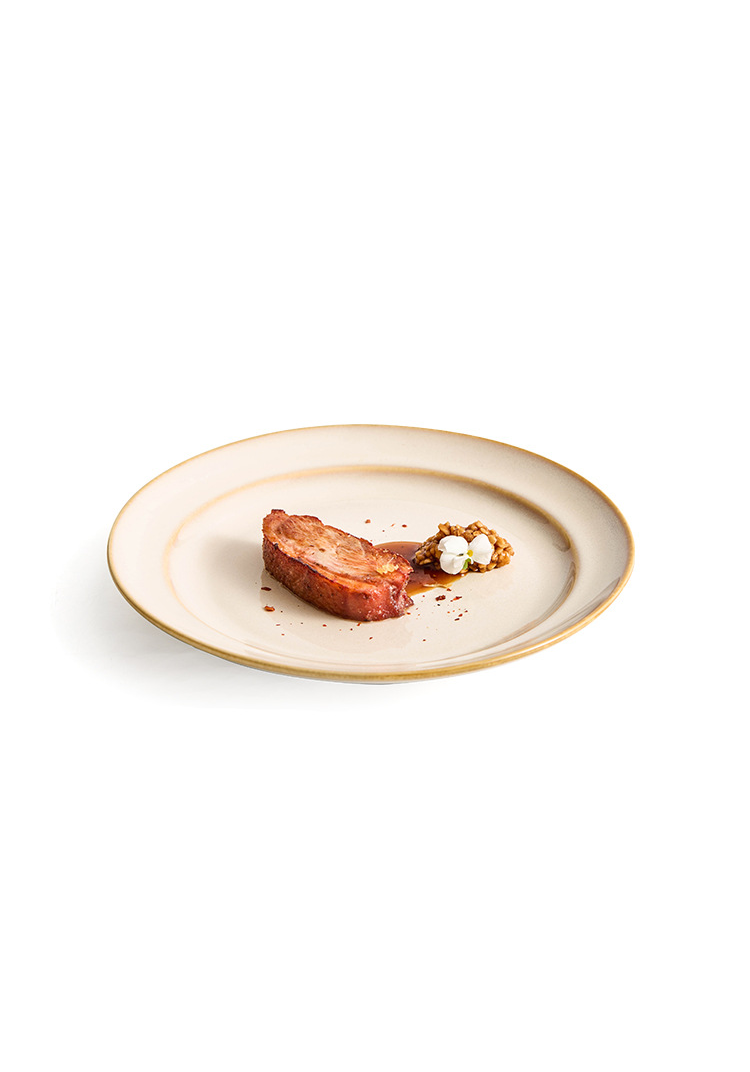 Heavyweight white and tan ceramic plate designed for luxury home hosting.